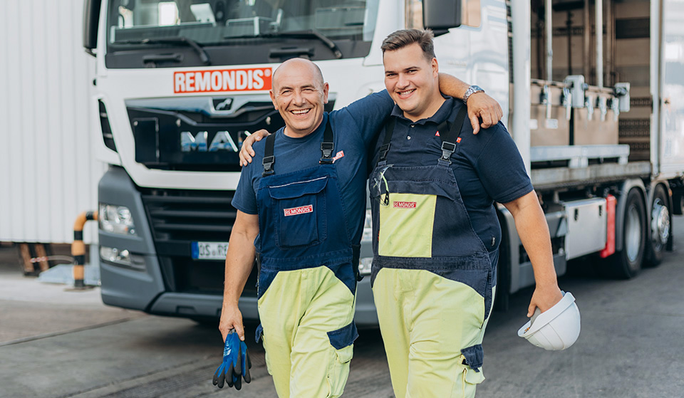 Two REMONDIS Industrie Service employees standing in front of a lorry