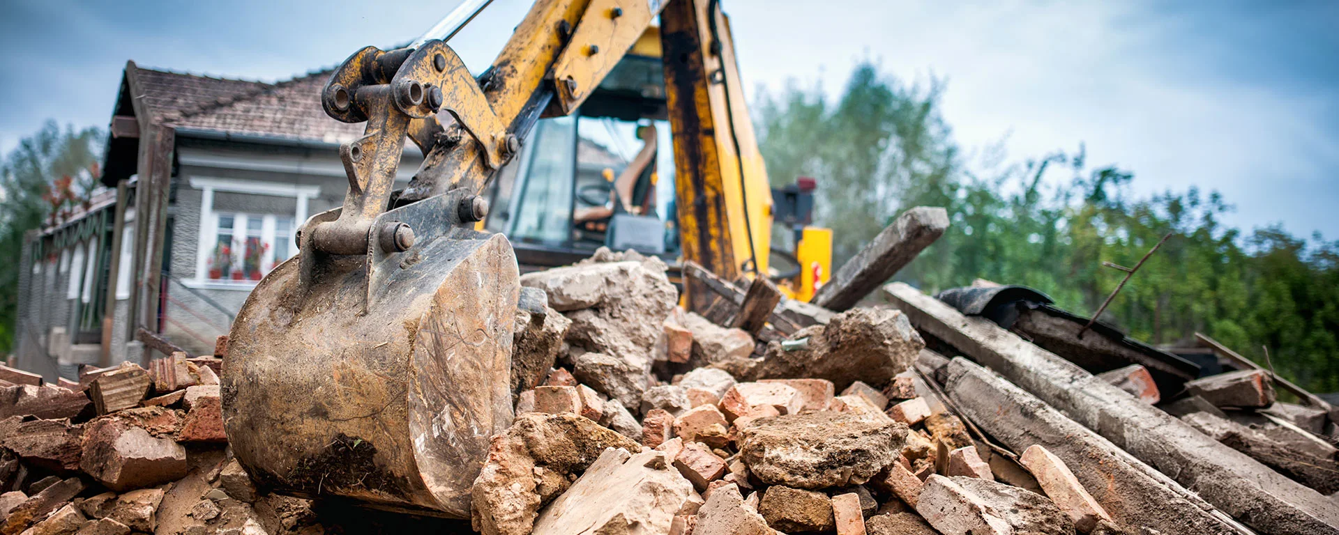 Baustelle auf der gefährliche Baumischabfälle mit einem Bagger verarbeitet werden