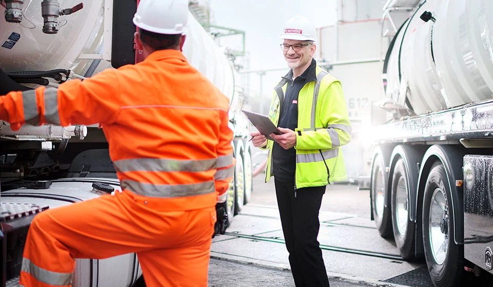 Mitarbeitende bei der Abfahrtkontrolle an einem Tankfahrzeug