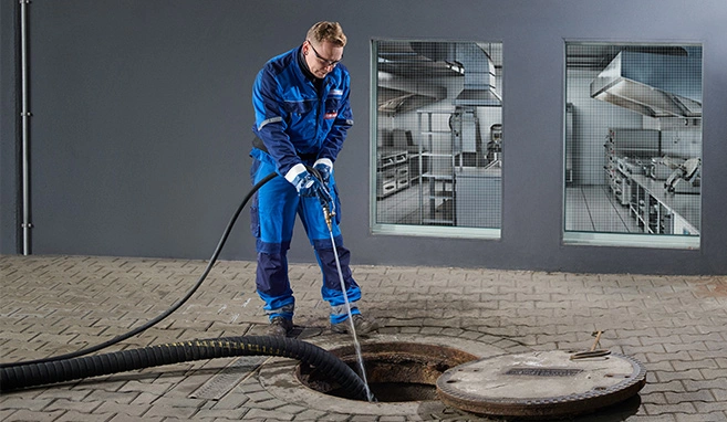 Mitarbeiter bei der Reinigung eines Fettabscheiders