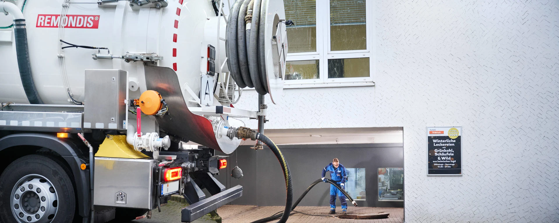 Mitarbeiter bei der Fettabscheider-Leerung mit einem Saugwagen