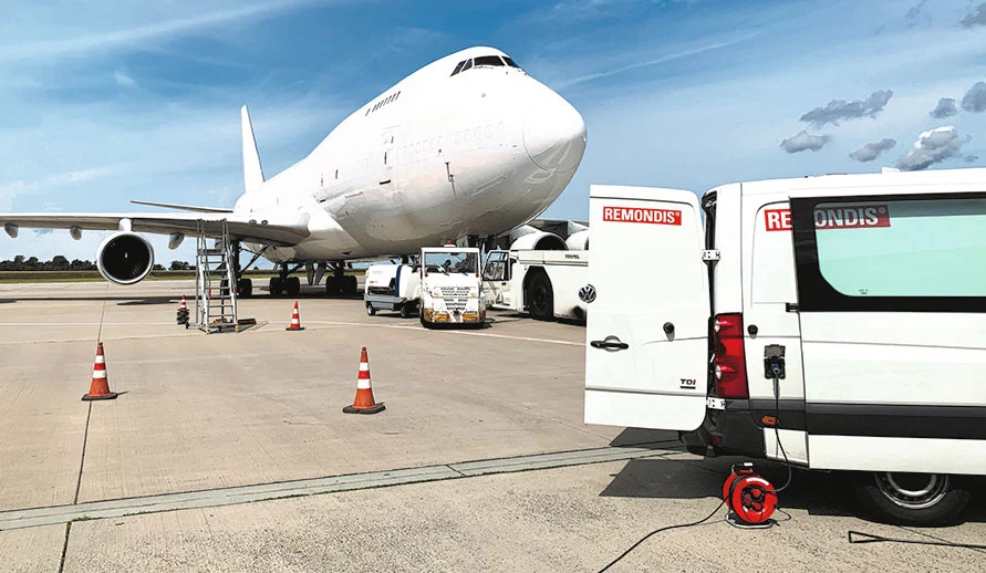 REMONDIS-Fahrzeug vor einem Frachtflugzeug am Flughafen