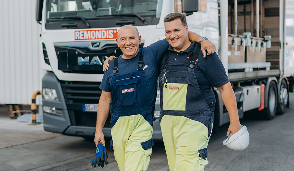 Two REMONDIS Industrie Service employees standing in front of a lorry